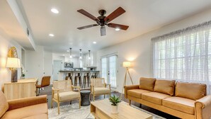A modern living room with a sofa, chairs, a coffee table, and a ceiling fan. - Family-friendly Home: 6 Mi to Downtown Mobile! (Mobile)