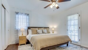 A bedroom with a bed, two bedside tables, a ceiling fan, and a window with blinds. - Family-friendly Home: 6 Mi to Downtown Mobile! (Mobile)