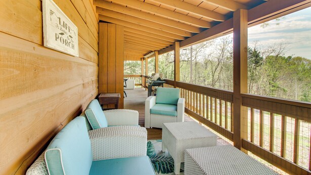 A covered porch with wicker furniture, a wooden ceiling, and a view of trees. - Cozy Cabin w/ Grill & Fire Pit By Dale Hollow Lake (Byrdstown)