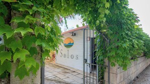 A building entrance with a sign reading "Salos," surrounded by greenery. - BIO AGRITURISMO SALOS (Otranto)
