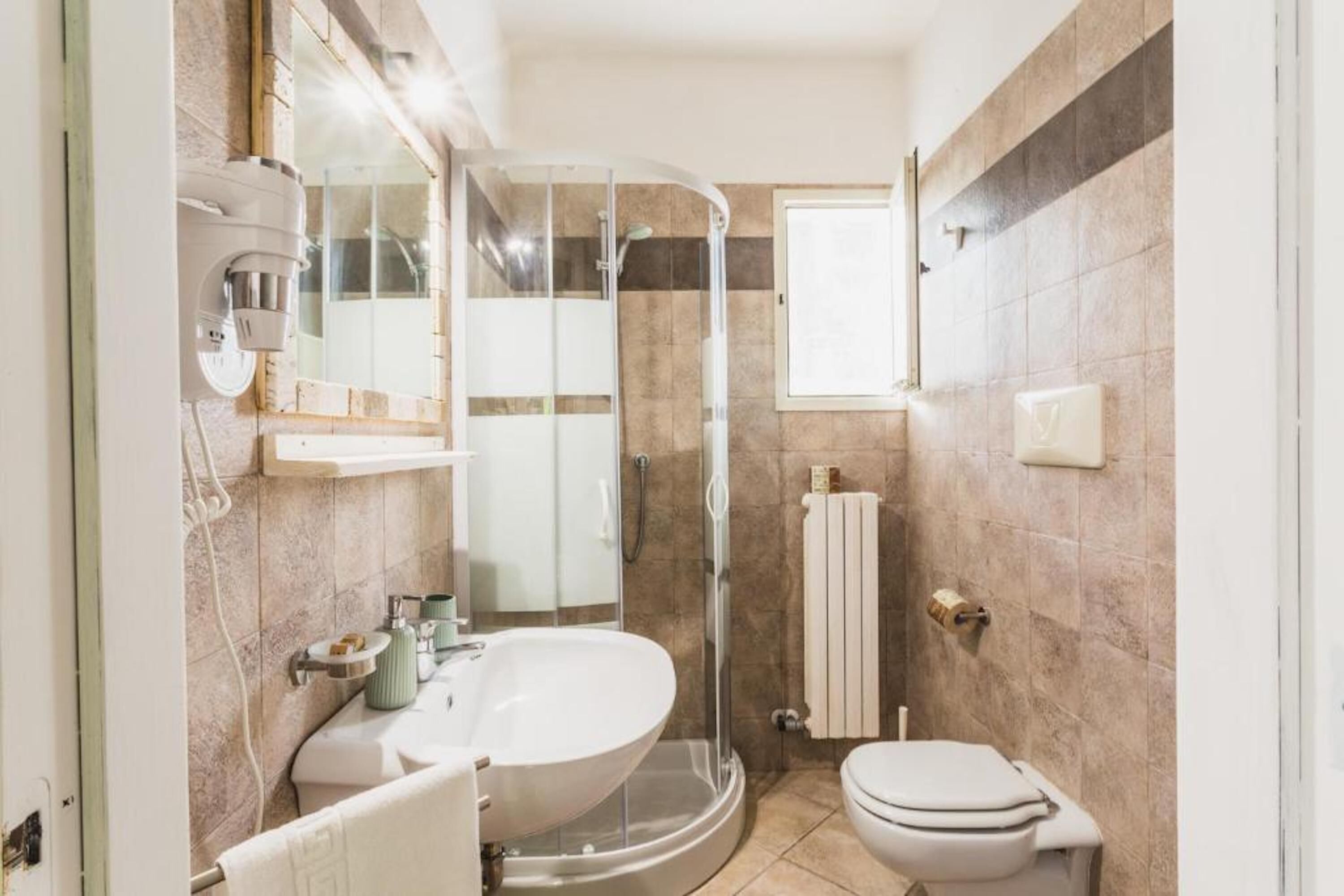 A bathroom with a bathtub, toilet, and shower area.