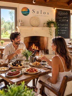 A restaurant interior with a fireplace, a signboard with the restaurant's name, and a menu board. - BIO AGRITURISMO SALOS (Otranto)