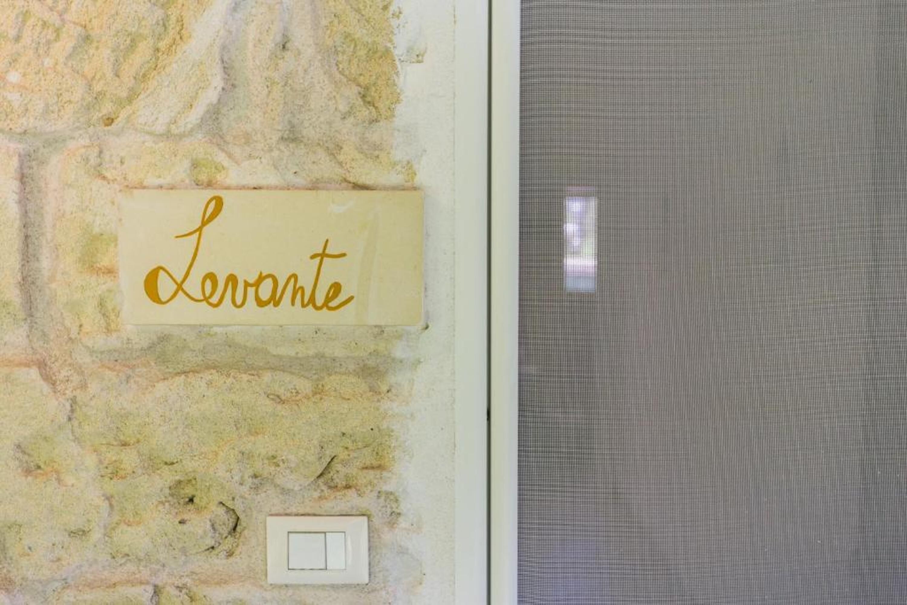 A wall with a sign that reads "Lerovante" and a light switch below it.