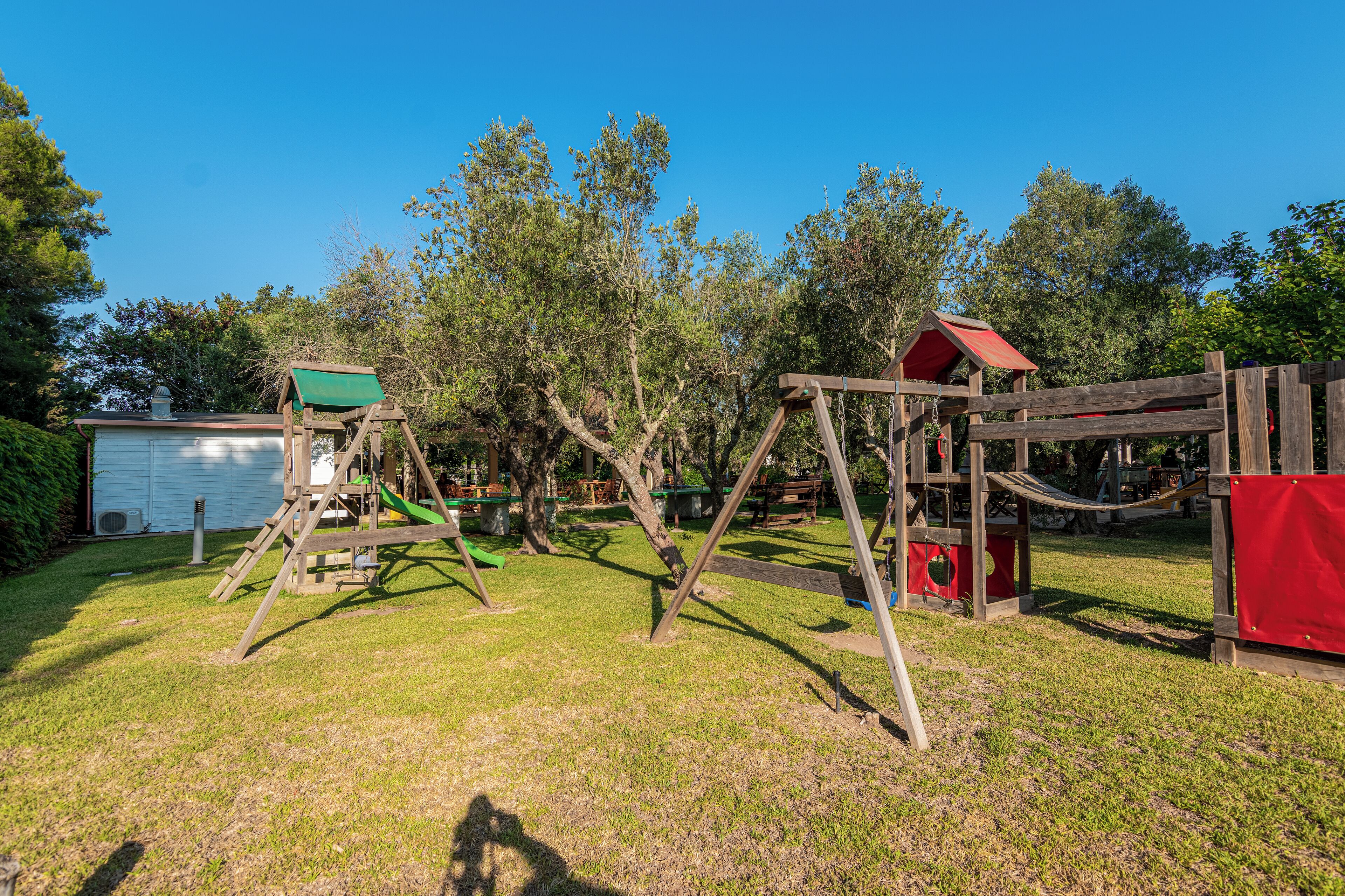 A playground with swings, a slide, and a climbing structure.