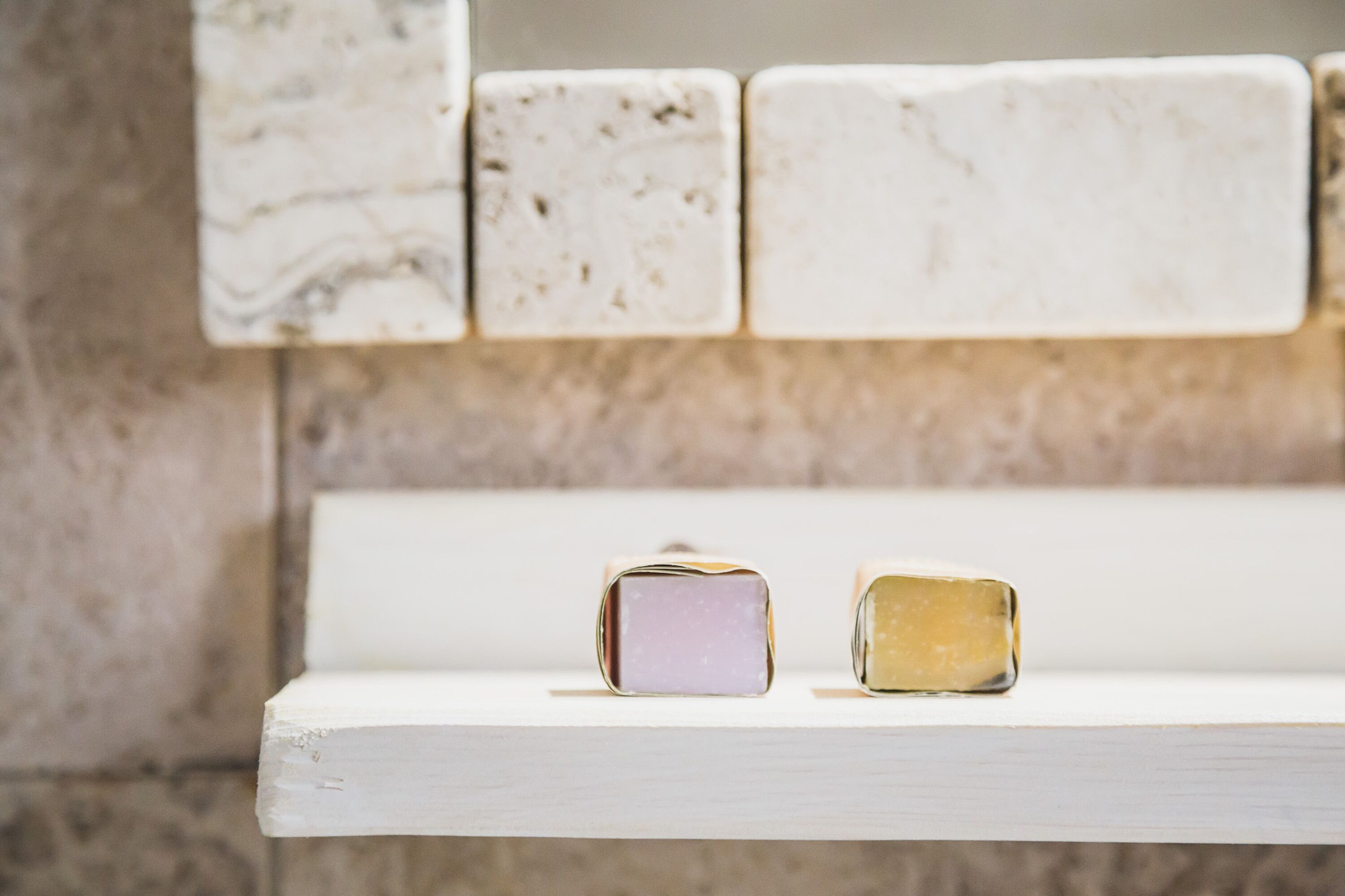 A white shelf with two blocks of soap.