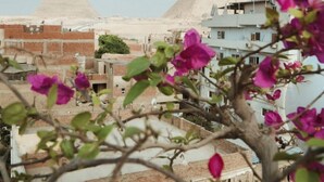 A view of two pyramids in the background with residential buildings in the foreground. - Jimmy Pyramids Hotel  (Giza)