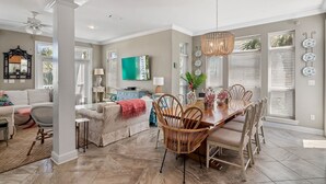 A spacious living room with a large dining table, comfortable seating, and a television. - 5BR Luxury Home with Multiple Lounges + Private Pool | La Contenta (Destin)