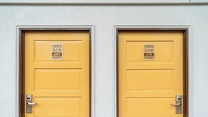 Two yellow doors with signs indicating 'G05 SUITE' and 'G06 SUITE'. - Mulyo Hotel (Port Dickson)