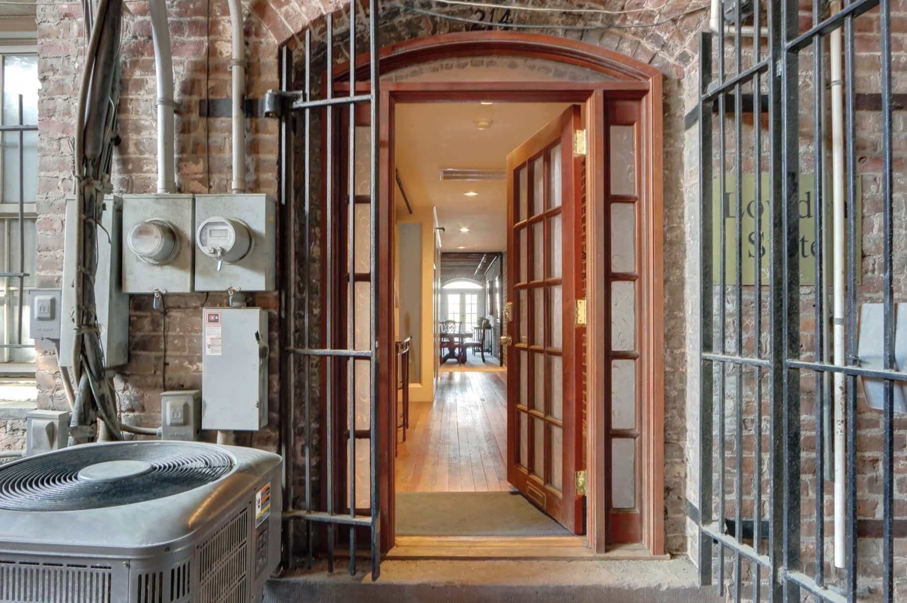 A hallway with a brick wall, a wooden door, and a radiator.