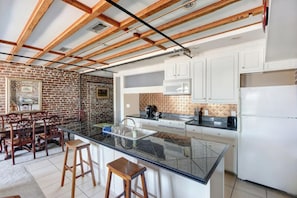 Enjoy cooking in this well-equipped kitchen with a central island, white cabinetry, and stainless steel appliances.