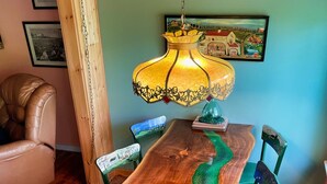 A dining table with a unique wood grain design and a green river-like pattern. - Big Pines at the Lake -  waterfront  - swimming, fishing, boating (Cooperstown)