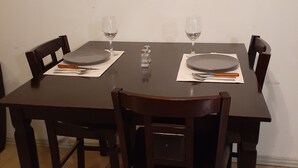Une table à manger dressée avec des assiettes, des couverts et des verres, et un panneau au-dessus indiquant une direction.