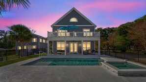 A two-story house with a balcony, a swimming pool, and a well-maintained lawn. - The Quiet Storm - Walk to Beach - 4BR/3BA - 3 Living Areas (North Myrtle Beach)