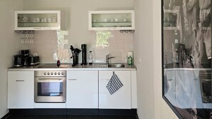 Eine moderne Küche mit Einbauofen, Kaffeemaschine und Spüle.