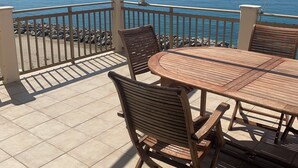 A terrace with a round wooden table and chairs, a railing, and a view of the sea. - Pizzo, Costa Degli Dei - Terrazza Sul Mare (Pizzo)