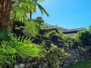 Escape to a tranquil retreat surrounded by lush greenery and a traditional building with a tiled roof.