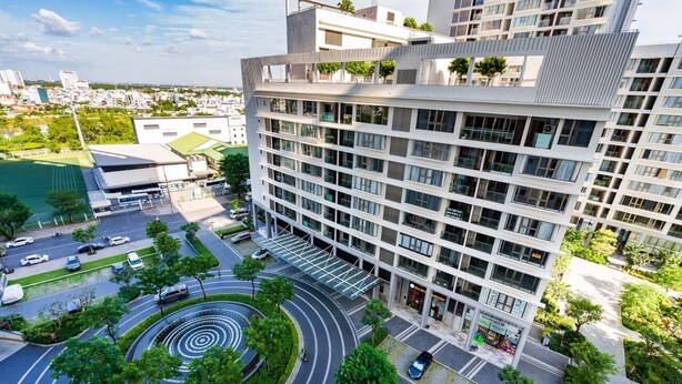 A modern multi-story building with a rooftop garden, a circular driveway, and a parking area. - Midtown My Hung Quan 7-Luxury Apartment (Ho Chi Minh City)