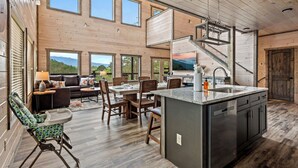 A spacious kitchen with a central island, large windows, and a view of the outdoors. - Spacious 4BD Lodge w/ POOL! Hot Tub + Theater Room (Sevierville)