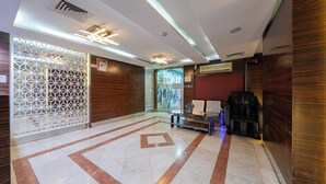 Un'ampia hall con pavimento a motivi geometrici, una reception e un'area salotto.