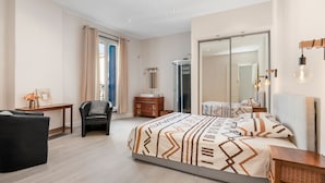 A modern bedroom with a large bed, a desk, a chair, a vanity, and a walk-in closet. - L'Ostal de Pomérols - Grande maison pour 10 (Pomérols)