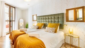 A hotel room with two beds, a large tufted headboard, a mirror, and a small bedside table with a lamp. - Great private terrace in the heart of the city centre  (Málaga)