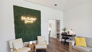 A modern living room with a green wall, two armchairs, a sofa, and a desk with a lamp. - Boho Chic Retreat Savannah/Dog Friendly/3 BD/2 BATH (Savannah)