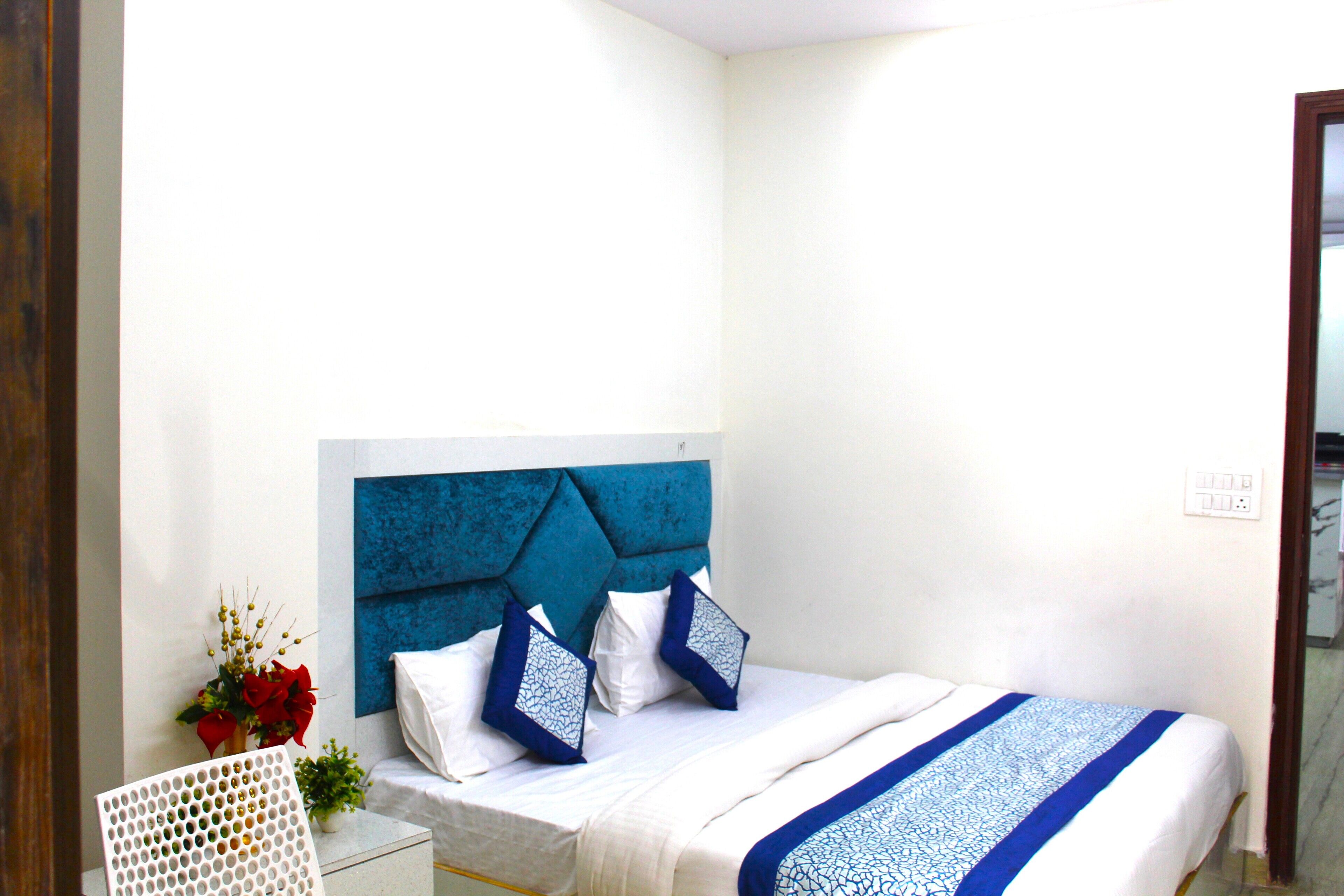 A neatly made bed with a blue headboard, white bedding, and decorative pillows.