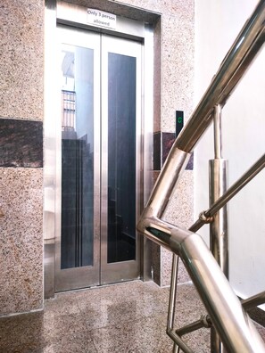 An elevator with a sign stating "Only 3 person allowed".