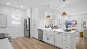 A modern kitchen with white cabinetry, stainless steel appliances, and pendant lighting. - 125 Yards to Private Beach Access. 350 Yards to Gulf Place. Private Pool. LSV. (Santa Rosa Beach)