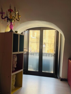 A room with a large arched doorway leading to an outdoor area, a bookshelf, and a chandelier. - LOFT P&G (Enna)