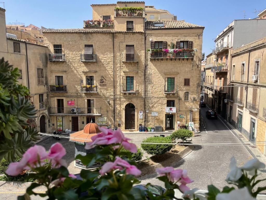 Un edificio de piedra con varios balcones, una pequeña cúpula y un letrero de restaurante.