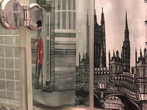 Une chambre dotée d’une grande fenêtre, d’un lit et offrant une vue sur un bâtiment historique.