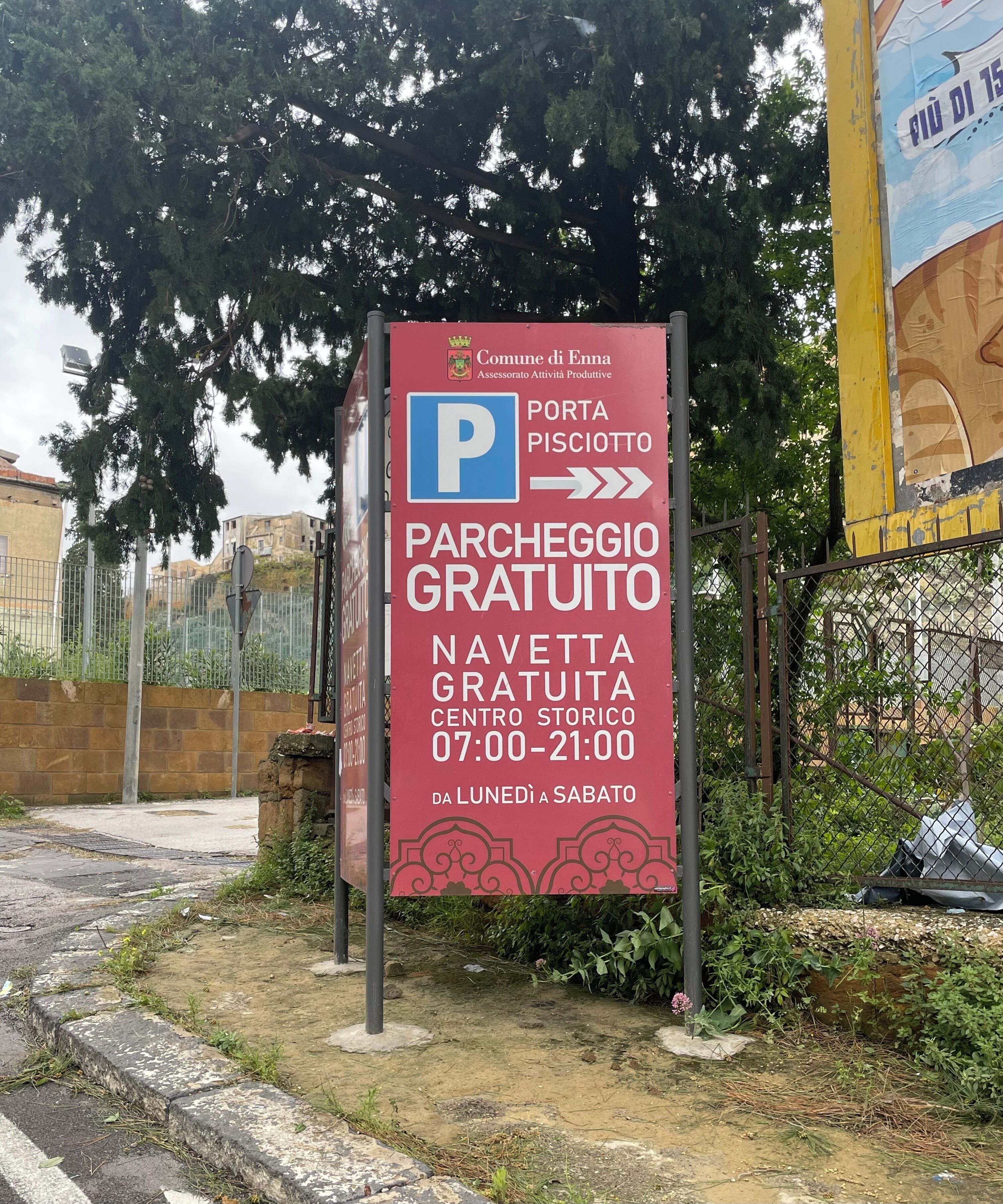 Segnale che indica parcheggio gratuito e un porticato che conduce al Piscinotto.