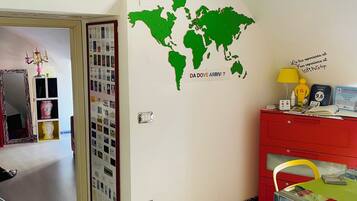 Una habitación con un mural de un mapa mundial, un archivador rojo, una lámpara amarilla y una silla roja.