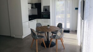 Eine moderne Küche mit weißen Schränken, einer schwarzen Arbeitsplatte und einem eingebauten Backofen.