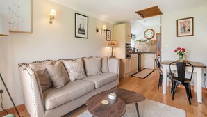 A living room with a sofa, coffee table, and a dining area with a table and chairs. - 1 bedroom accommodation in Bognor Regis (Bognor Regis)