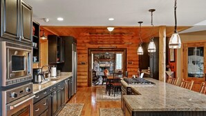 Une cuisine moderne dotée d’appareils électroménagers en acier inoxydable, de touches décoratives en bois et d’un îlot central.