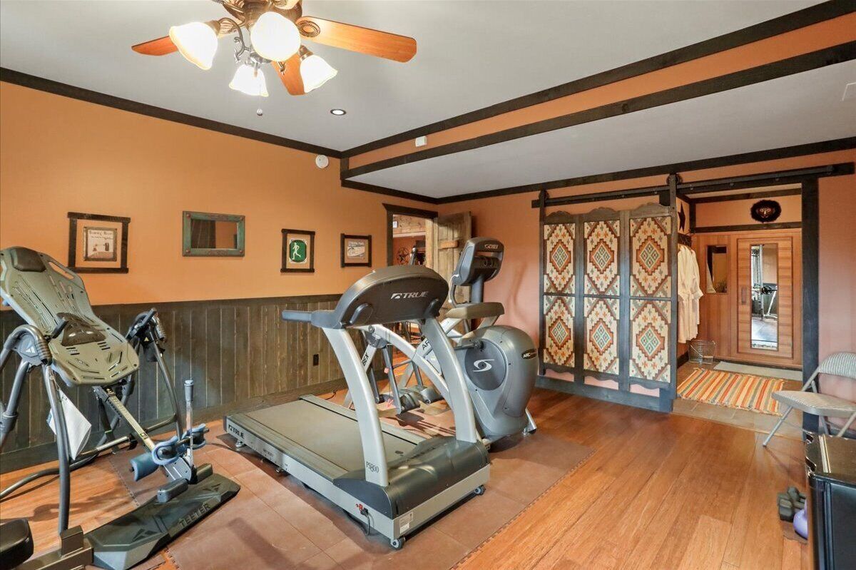 Ein Fitnessraum mit Laufbändern, Ergometer und Deckenventilator.
