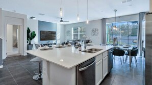 A modern kitchen with a central island, stainless steel appliances, and pendant lighting. - BV310MB - Disney & Universal heroes - 16 guests (Kissimmee)