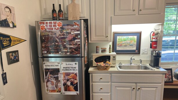 A kitchen with a stainless steel refrigerator, white cabinets, a microwave, and a sink. - Apartment in Downtown Clemson. Just a few minutes to Campus & Football Stadium. (Clemson)