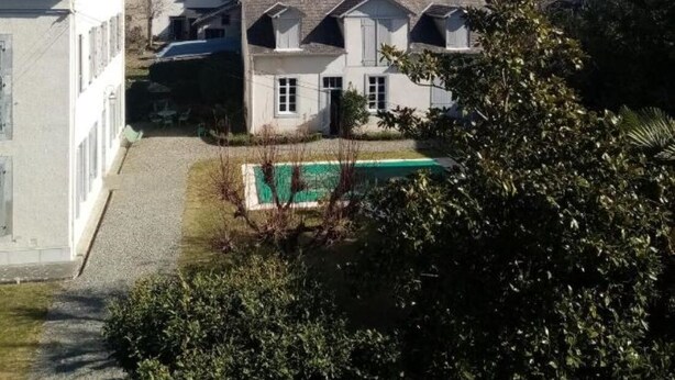 A residential area with a swimming pool, houses, and a church.