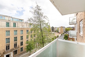 A multi-story building with a balcony overlooking a street.