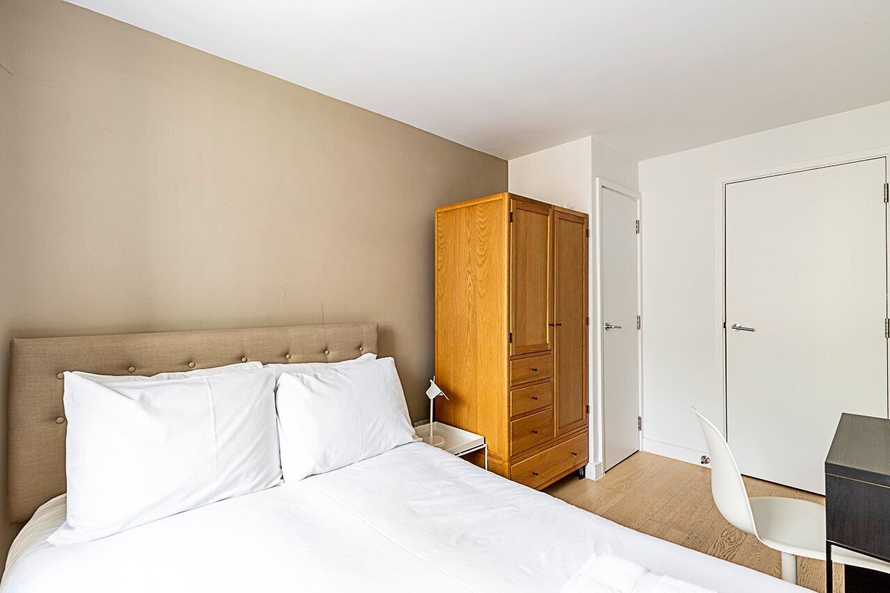 Une chambre à coucher avec un lit, une armoire, un bureau et une chaise.