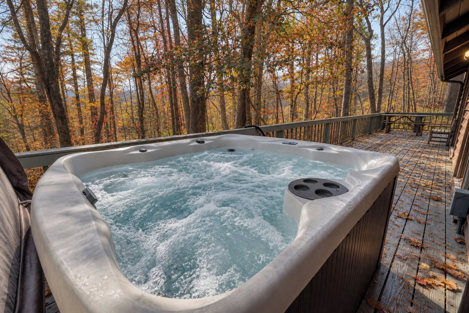 Un jacuzzi con cubierta de madera y vista a un bosque.