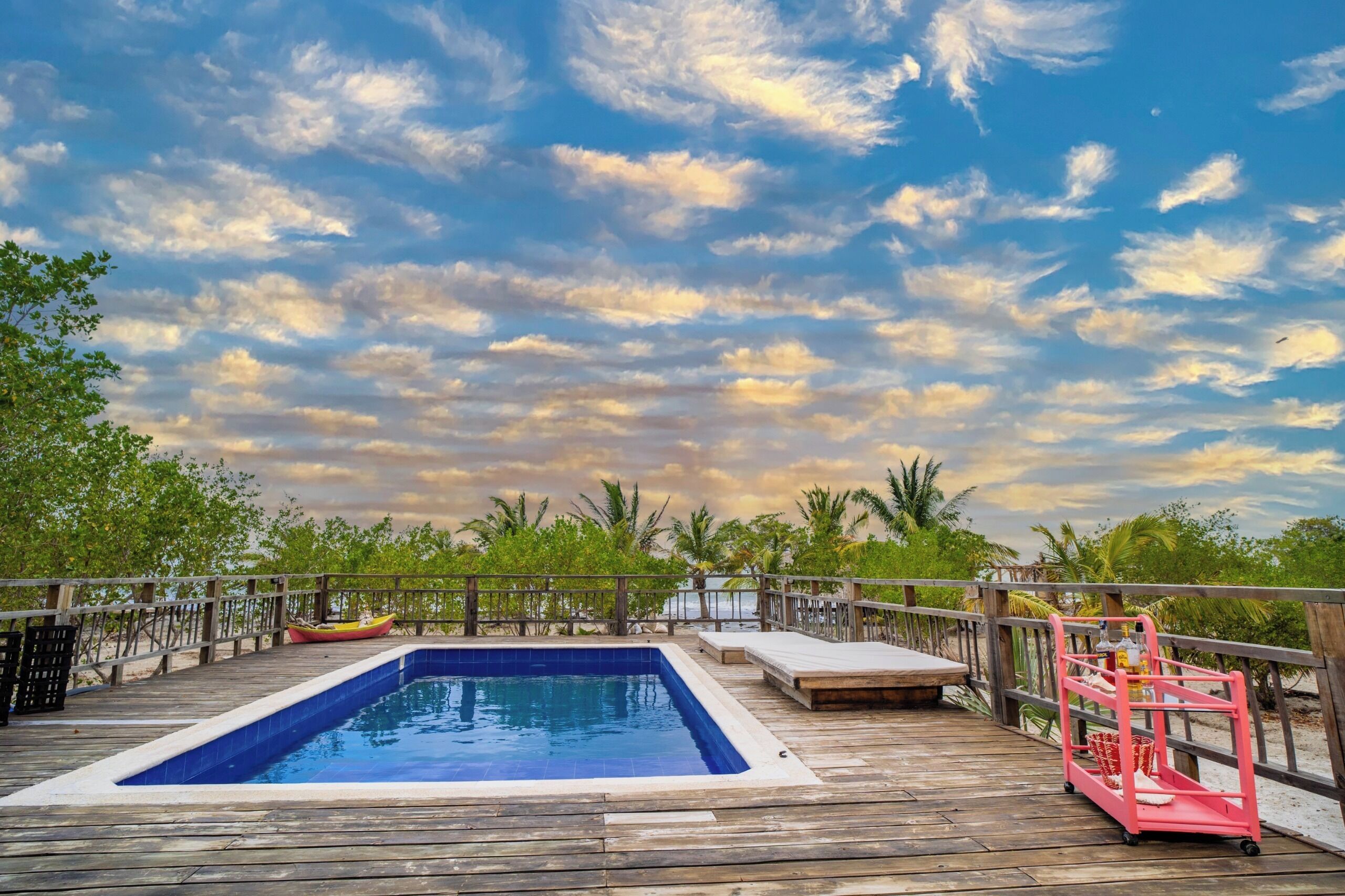 Una piscina al aire libre, sombrillas, sillones reclinables de piscina