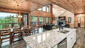 A spacious wooden cabin with a large kitchen, dining area, and a cozy living room. - Smoky Horizon by Avantstay Game Room, Movie Theater, Deck w Hot Tub Views! (Sevierville)