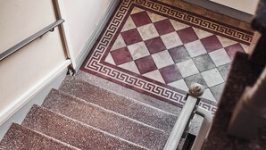 A staircase with a patterned floor and a handrail.