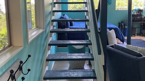A staircase with teal walls and white railings leading to a bedroom with a bed and a window. - Manta Suite w/ ocean view and sleeping 6 --TA-154-746-2656-01 (Kealakekua)