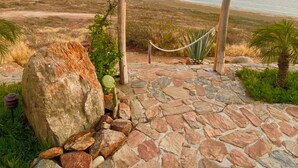 A stone pathway leading to a wooden sign with the text "MIRADOR LABO SANTOS".