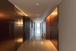 A corridor with a polished floor, recessed lighting, and wooden doors. - ShangHai NvYan Hotel (Shanghai)